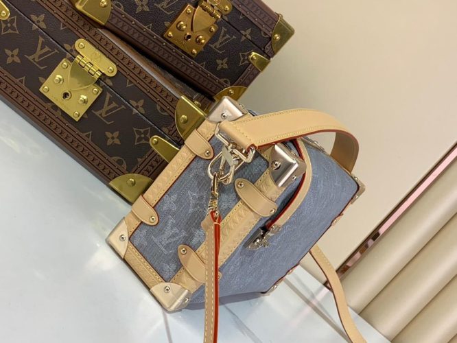 A compact Louis Vuitton trunk-style bag in denim canvas with monogram pattern, natural leather trim, and silver-tone hardware.